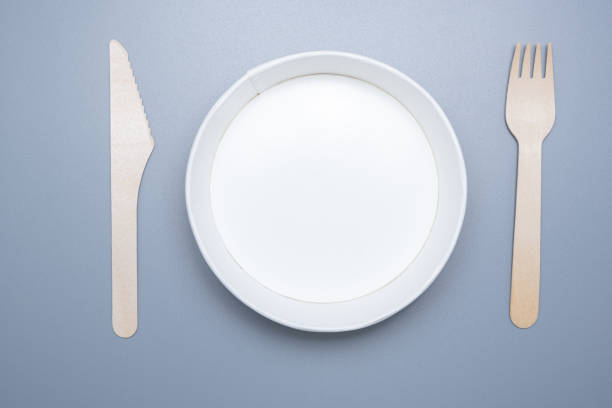 istock Wooden and cardboard disposable tableware on a gray background. Environmentally friendly products 1306974393