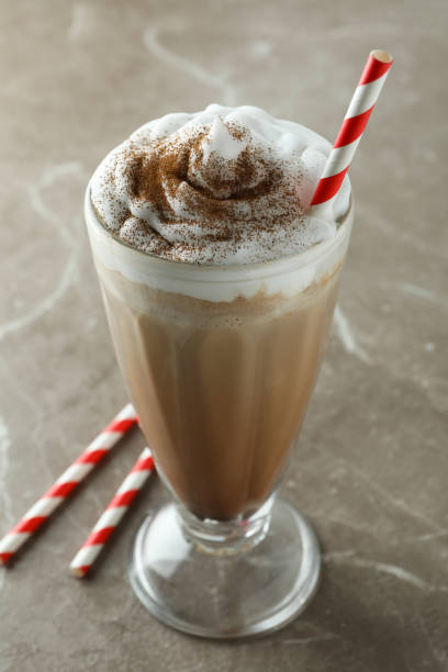 istock Glass of chocolate milkshake and straws on gray table 1306976479