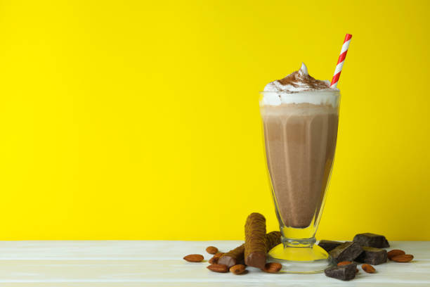 istock Chocolate milkshake, almond and chocolate against yellow background 1306976628