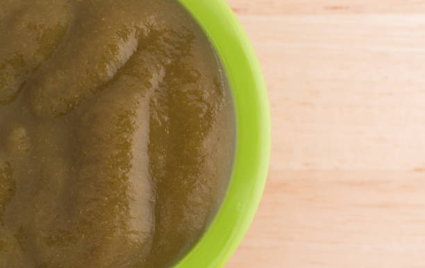 istock Bowl of spinach baby food on a table 1306978032