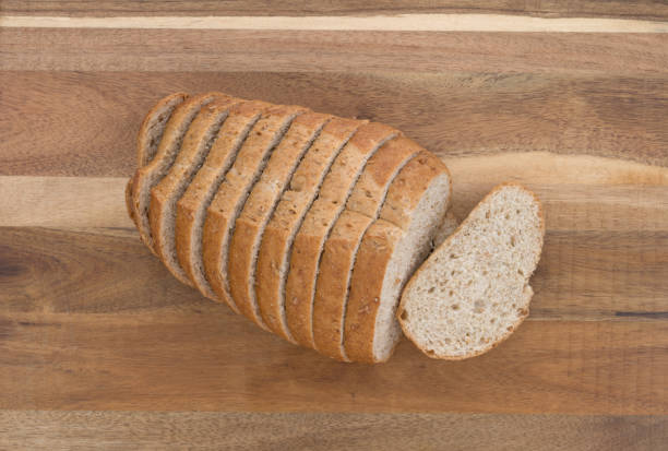 istock Small loaf of sliced wheat bread on a cutting board 1306978069
