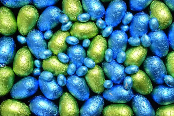 istock Pile or group of multi colored and different sizes of colourful foil wrapped chocolate easter eggs in blue, yellow and lime green. 1306996589