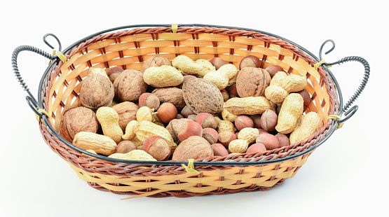 Blend of nuts in wicker basket on white background. The concept of proper nutrition