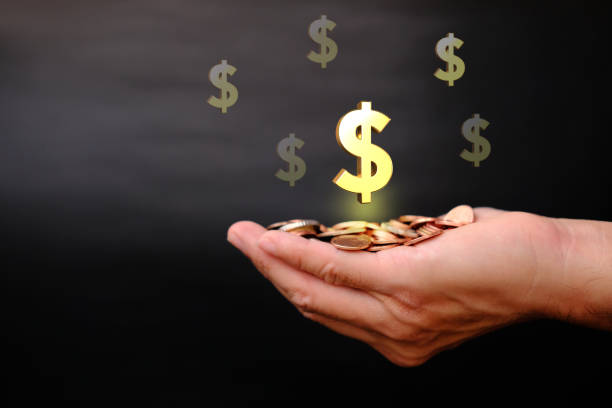 istock Hand holding coins on black background and saving money concept 1307001691