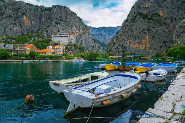 Photo of Small harbor with fishing and tourist boats in Omis, Croatia