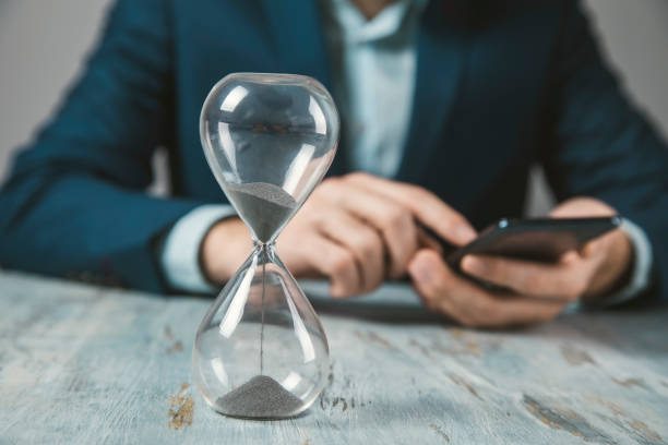 istock man holding phone with hourglass 1307002842