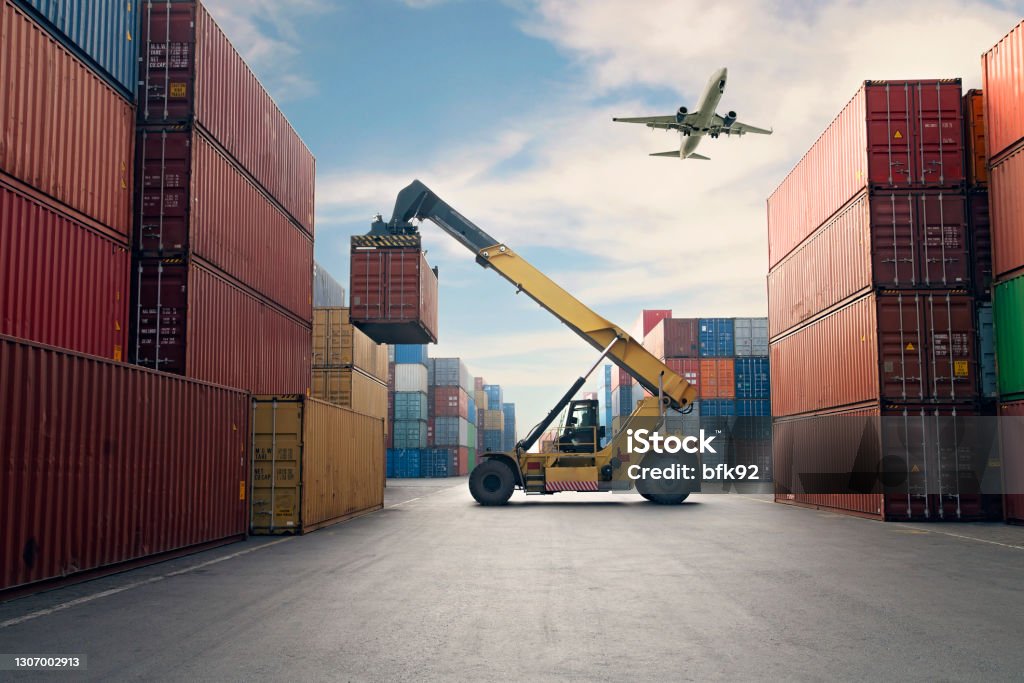 Airplane flying above container port. Freight Transportation Stock Photo