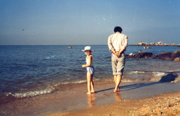 jaren '80 china meisje en vader oude foto van het echte leven - strand fotos stockfoto's en -beelden