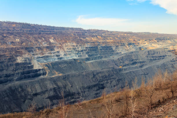 istock Huge iron ore quarry with working dump trucks and excavators 1307007258