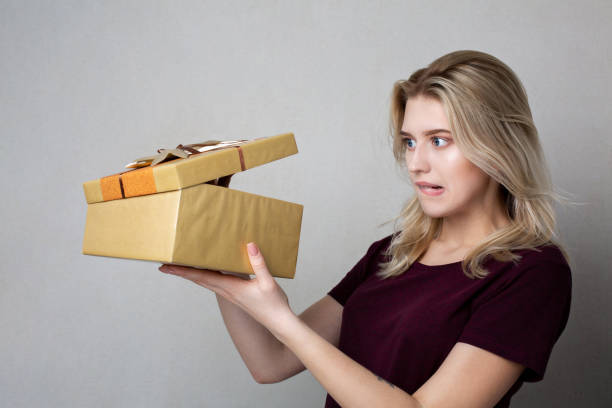 istock Scared blonde woman looking to a gift box. Empty space 1307007277