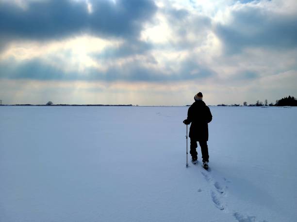 istock Man hiking in snow w cleats and poles 1307008522