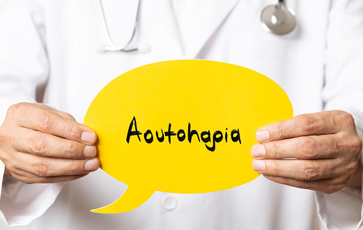 Male doctor holding and showing yellow speech bubble.