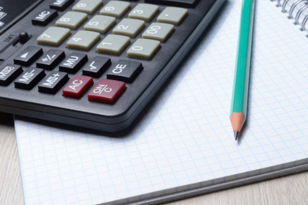 istock calculator, notebook and pencil lie together. close-up. 1307013038