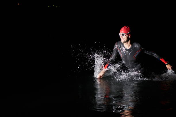 istock triathlon athlete finishing swimming training at dark night 1307014664