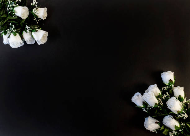 istock Flat Lay, postcard for death, funeral. White roses on a black background 1307017335