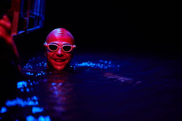 istock authentic triathlete swimmer having a break during hard training on night neon gel light 1307018672