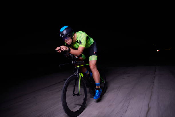 istock triathlon athlete riding bike fast at night 1307018933