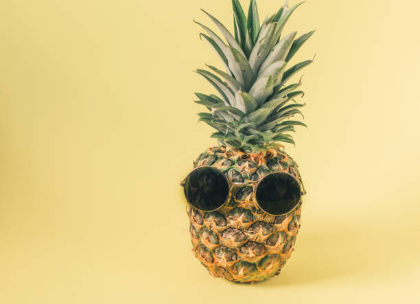 istock hipster pineapple with sunglasses over pastel yellow background. Minimal  creative concept 1307020864