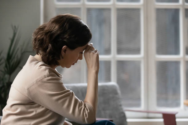 istock Rear view thoughtful mature woman touching forehead, sitting alone 1307021040