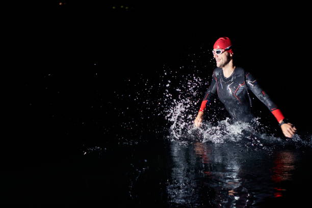 istock triathlon athlete finishing swimming training at dark night 1307021166