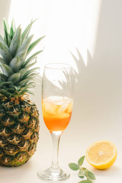 istock Cold refreshing drink with lemon orange slices by the glass on white background on directly sunlight with shadows 1307021495