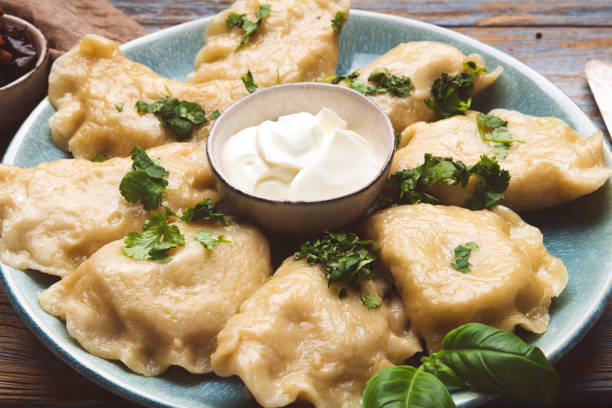 Mashed potato stuffed dumplings with cream close up of a Mashed potato stuffed dumplings pierogi stock pictures, royalty-free photos & images