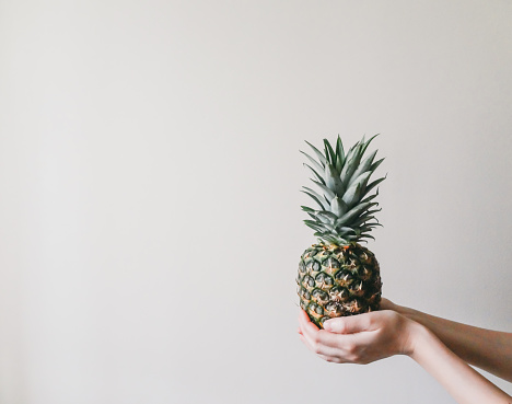 Portrait of girl holding a pineapple