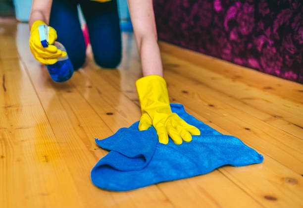 Cleaning the floors with a mop.