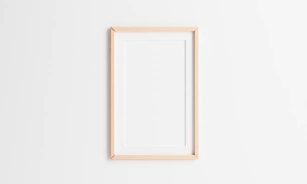 istock Wooden picture frame hanging on white wall background. 2:3 ratio photo frame size. 3D illustration rendering graphic interior design 1307023443