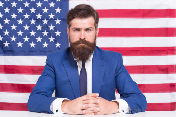 istock Man officiary placement working for american government USA flag background, serious situation concept 1307023507