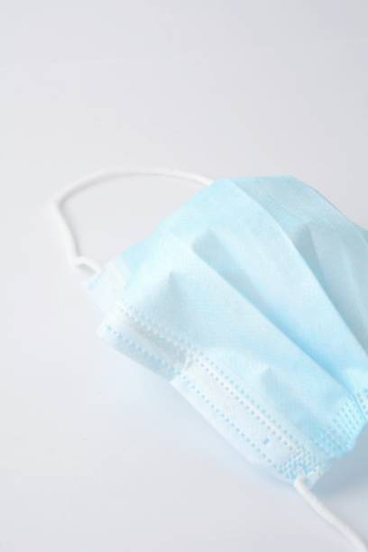 istock Blue surgical face mask on white background 1307023573