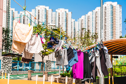 Hanging drying clothes in Hong Kong. In the background high rise apartment buildings.