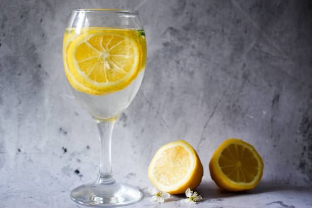 istock Wine glass with lemons and water on a gray background 1307024288