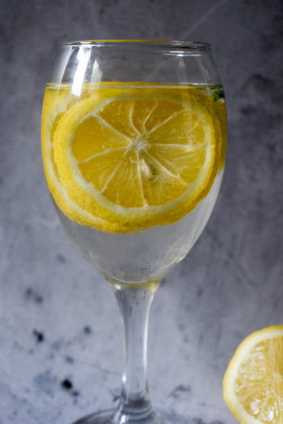 istock Wine glass with lemons and water on a gray background 1307024289