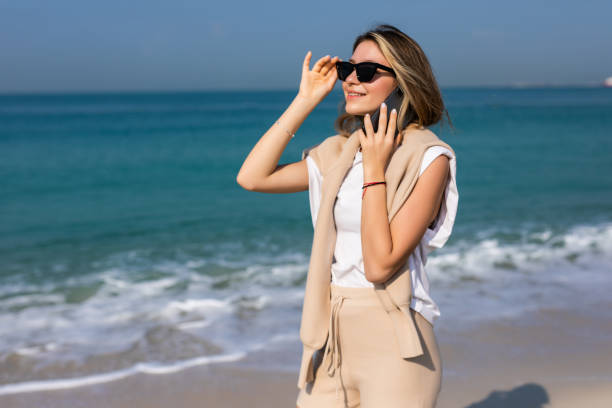 istock Young woman talking on the mobile phone at the seaside 1307024977