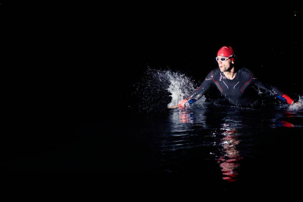 istock triathlon athlete finishing swimming training at dark night 1307026704