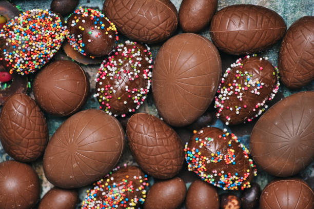 Chocolate Easter eggs on a table top view Chocolate Easter eggs with dessert sprinkles on a table top view background pattern flat lay chocolate truffle making stock pictures, royalty-free photos & images