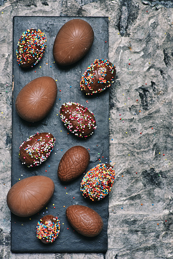 Chocolate Easter eggs with dessert sprinkles on a table top view