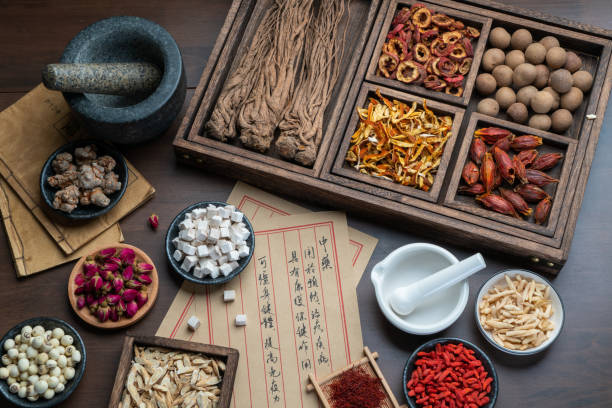 istock Ancient Chinese medicine books and herbs on the table 1307030310