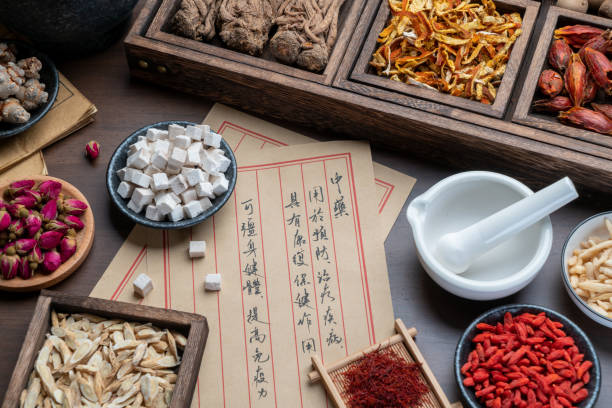 istock Ancient Chinese medicine books and herbs on the table 1307030364