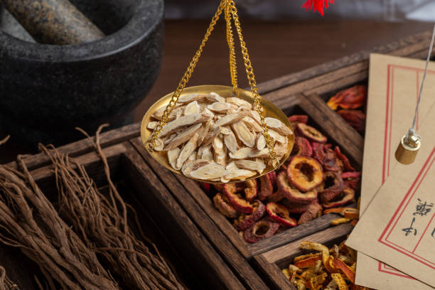 istock Ancient Chinese medicine books and herbs on the table 1307030427