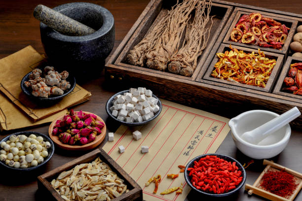 istock Ancient Chinese medicine books and herbs on the table 1307030706