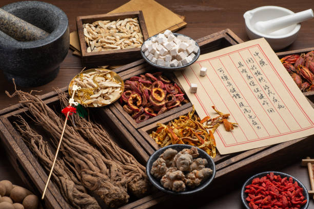 istock Ancient Chinese medicine books and herbs on the table 1307030832