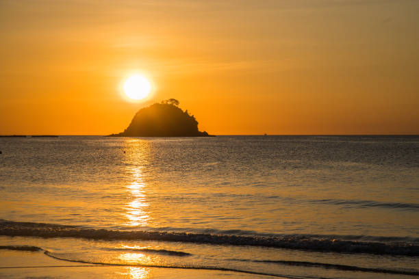 istock Sunset in a beach with an island in the background 1307031468