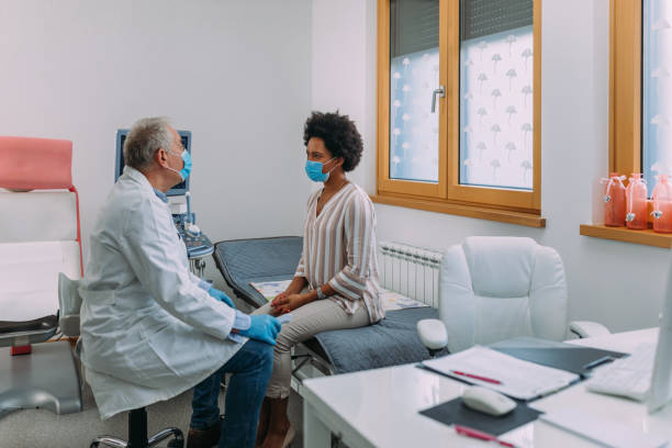 Patient talking with doctor Photo of an african american woman sitting and talking with a doctor. patience stock pictures, royalty-free photos & images
