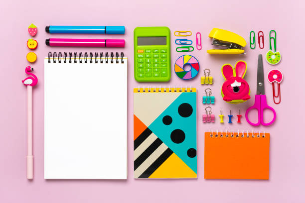 istock Supplies - scissors, pencils, paper clips, note, stapler, calculator, notepad on pink background 1307037361