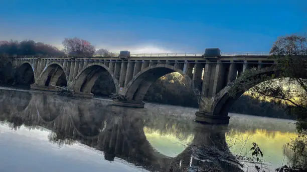 Constructed in 1925, the RF&P Railroad Bridge crosses over the Rappahannock River at Fredericksburg, Virginia. Seen here reflecting on the river beneath at dusk.o