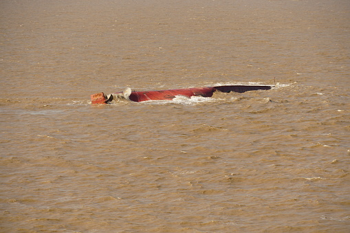 Bottom of the capsized ship with rudder and propeller in the muddy river approaching to the Shanghai, China.
