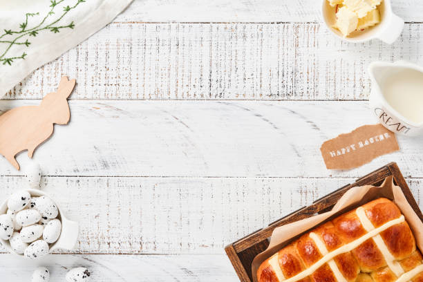 istock Easter Hot Cross Buns. Traditional breakfast and Easter baking holiday decorations rabbiton white wooden background. Bright colors, view from above on wooden table. 1307040100