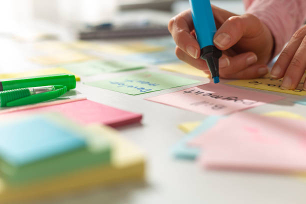 istock Business people write notes using stickers on paper. Brainstorming concept. Team meeting work on a project, develop ideas. 1307042801